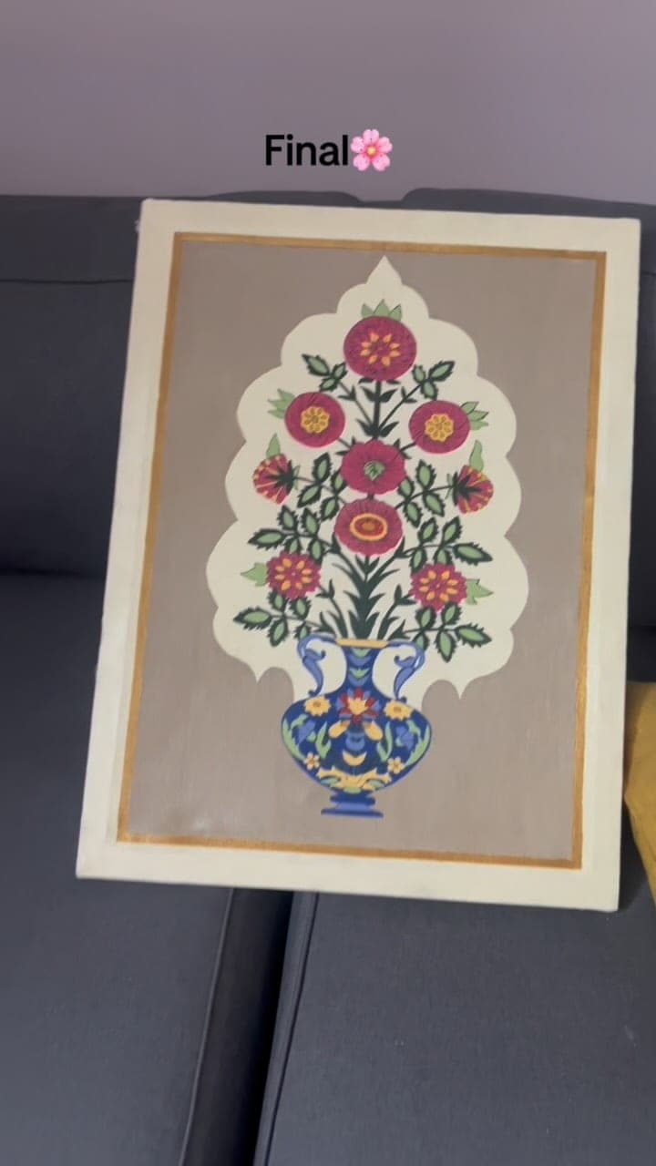 The finished Mughal floral canvas propped on a sofa
