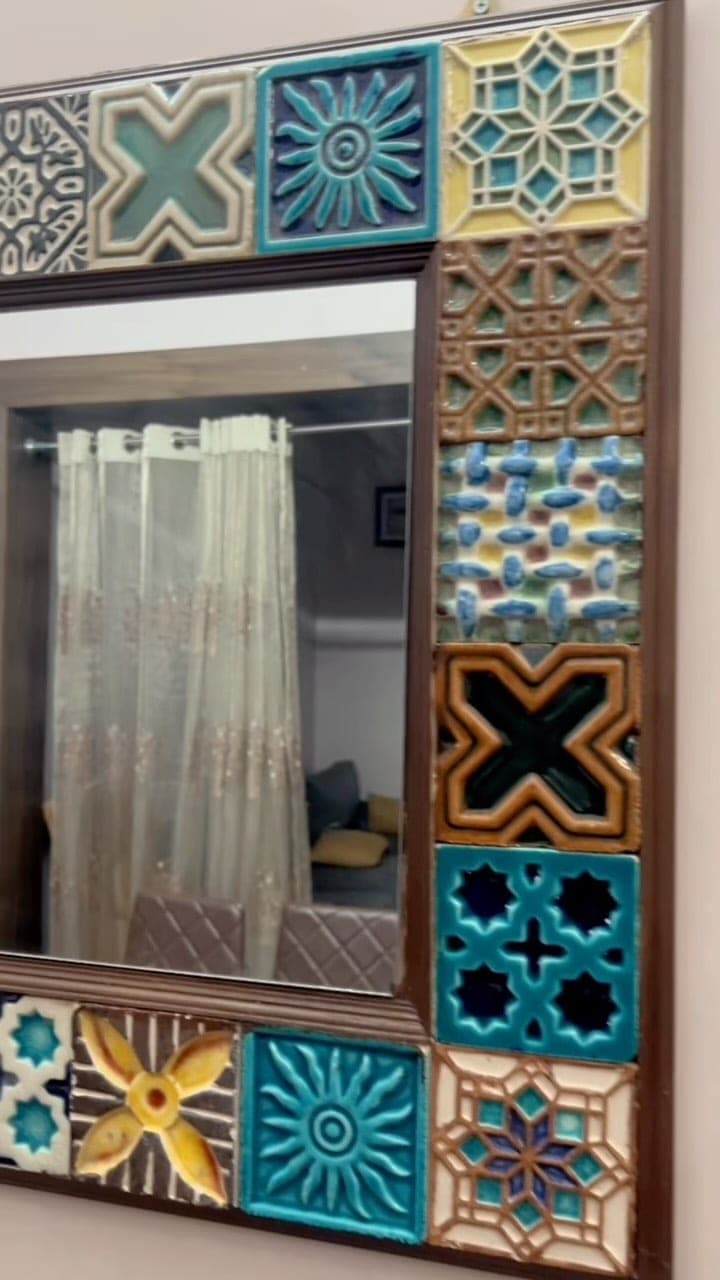 Mirror framed in hand-made patterned tiles in blue, teal and terracotta