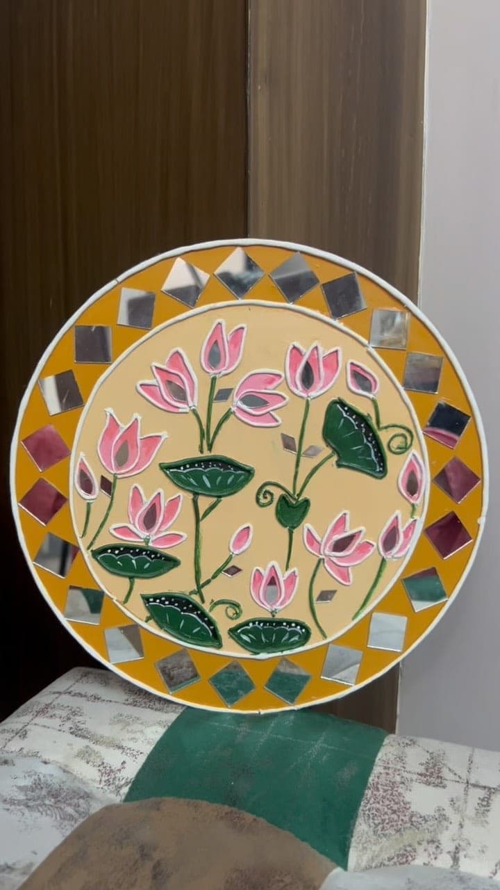 Lippan art of pink lotus flowers with mirror centres on a mustard base