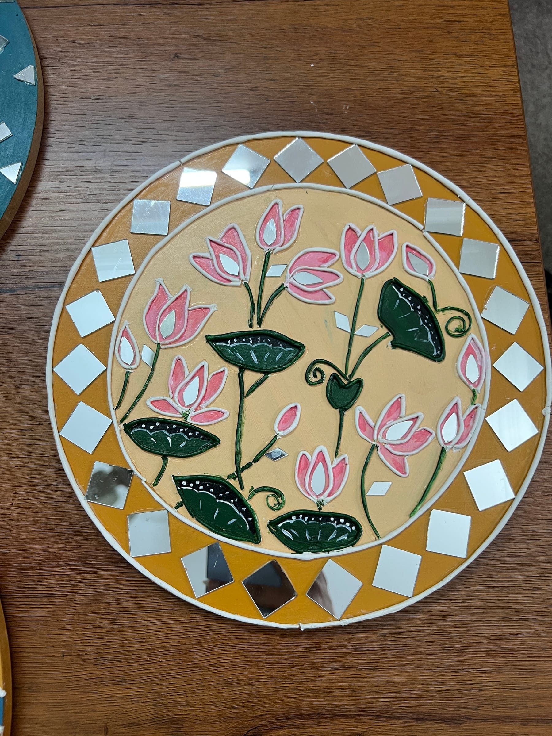 Lippan art of pink lotus flowers with mirror centres on a mustard ground, ringed with mirror diamonds